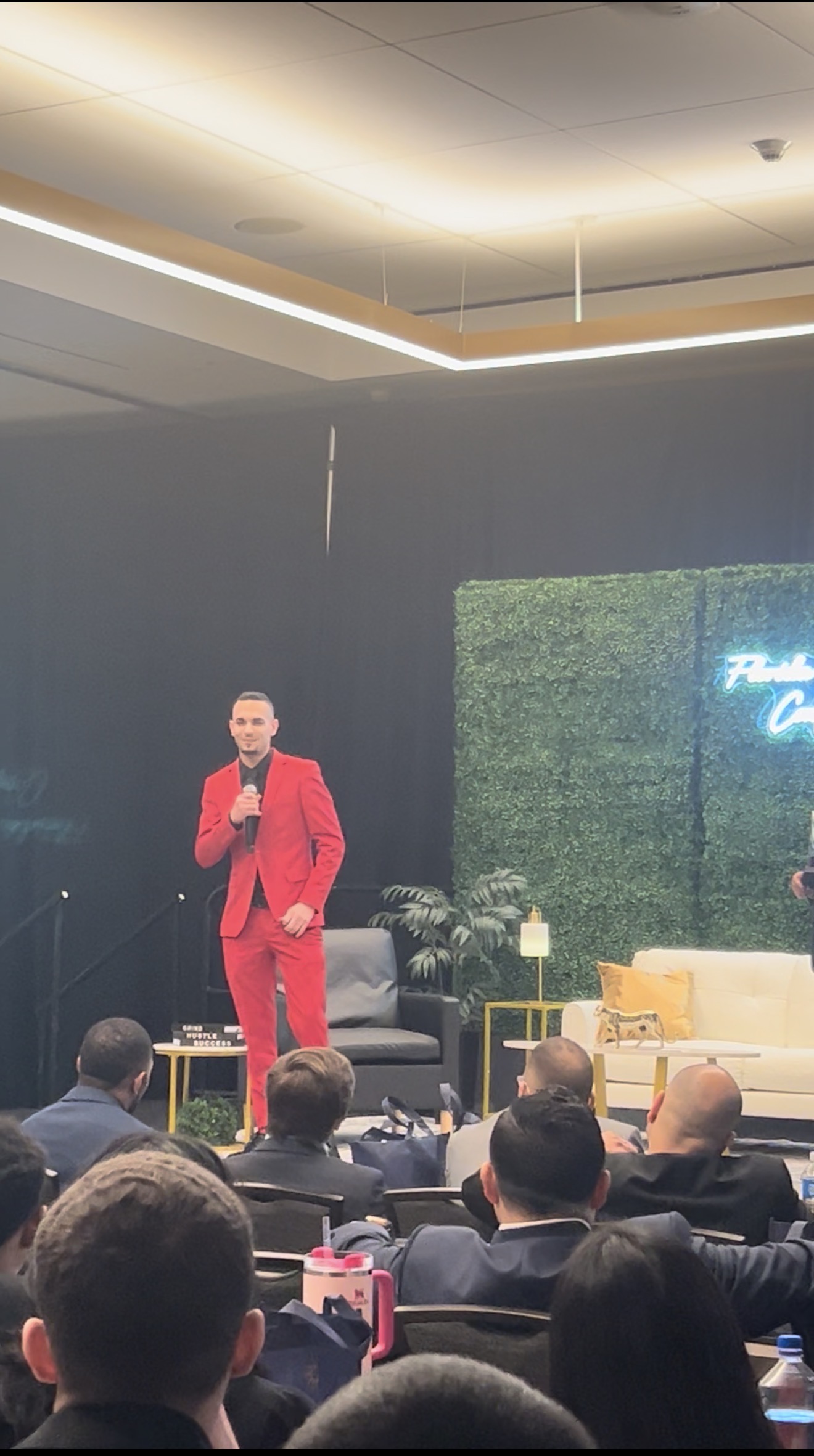 Fine Line Vision leader speaking on stage in a red suit